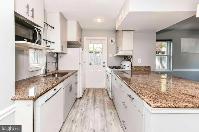 a large kitchen with stainless steel appliances granite countertop a lot of counter space and wooden floor