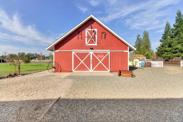 a kitchen with granite countertop a stove a sink and white cabinets with wooden floor