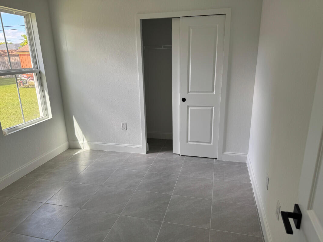1073 Southwest Benchor Avenue Port St. Lucie, FL 34953 - Photo 13 of 23 an empty room with windows and closet