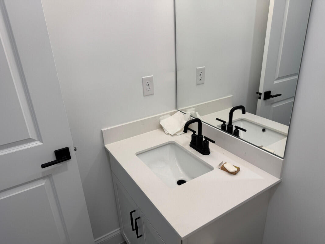 1073 Southwest Benchor Avenue Port St. Lucie, FL 34953 - Photo 18 of 23 a bathroom with a sink and a mirror