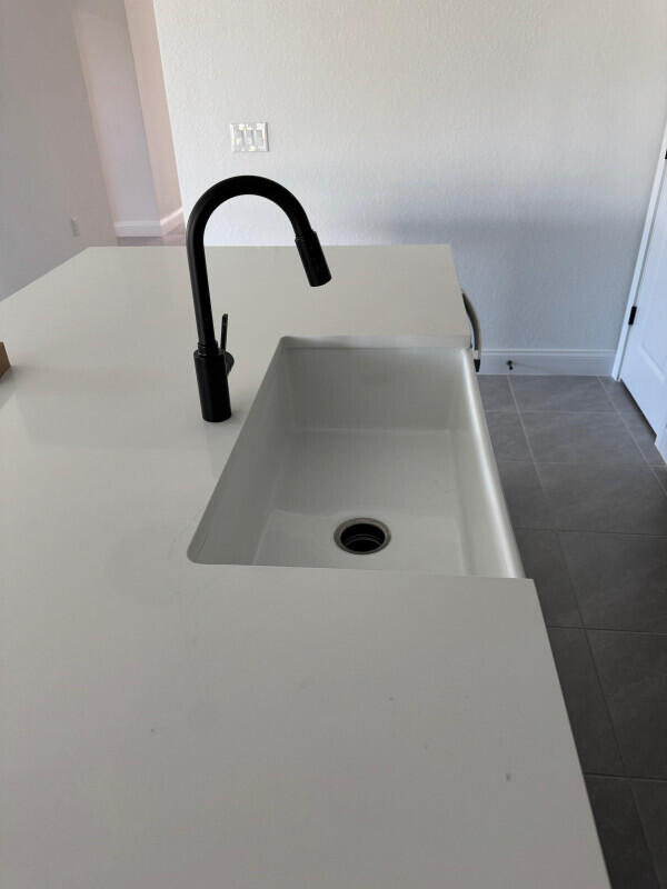 1073 Southwest Benchor Avenue Port St. Lucie, FL 34953 - Photo 7 of 23 a close view of a sink a faucet and a window in a bathroom