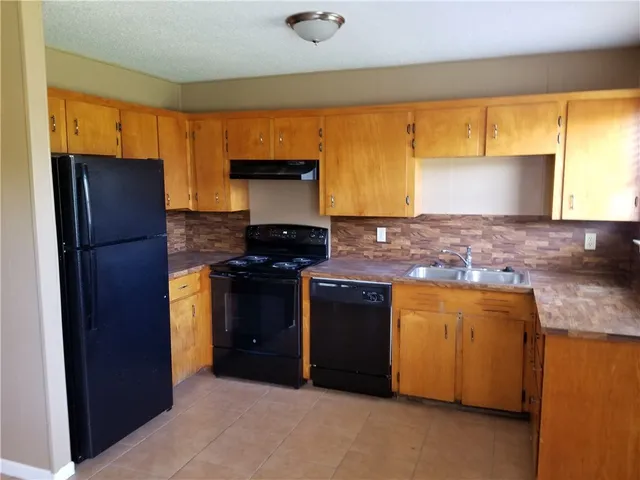 a kitchen with stainless steel appliances granite countertop a refrigerator and a stove