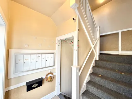 a view of staircase with railing and white walls