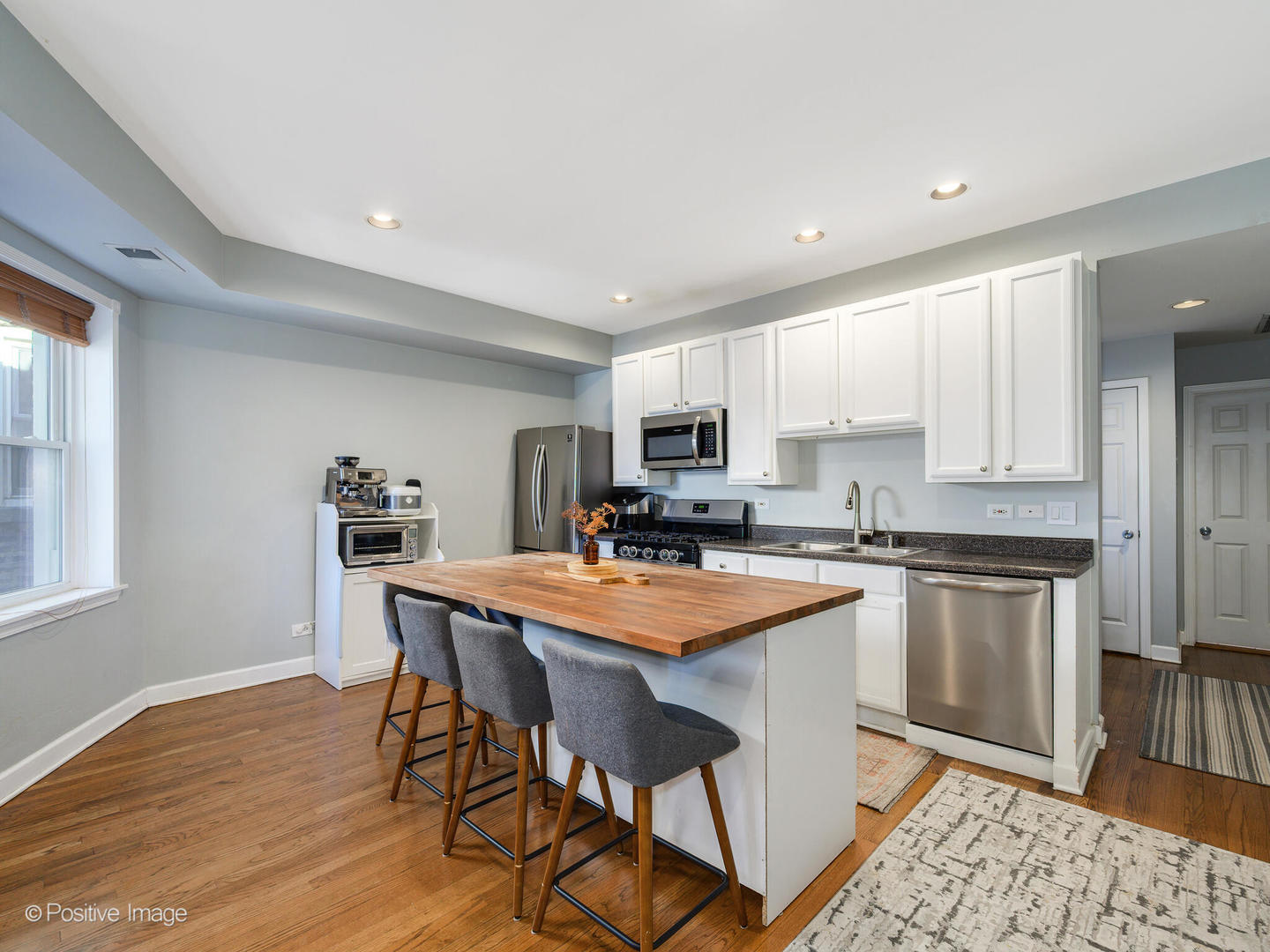 4022 North Monticello Avenue, Unit 3N Chicago, IL 60618 - Photo 7 of 21 a kitchen with stainless steel appliances granite countertop a table chairs sink and cabinets