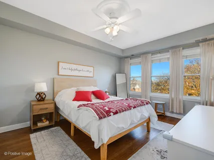a bedroom with a bed a rug and a large window