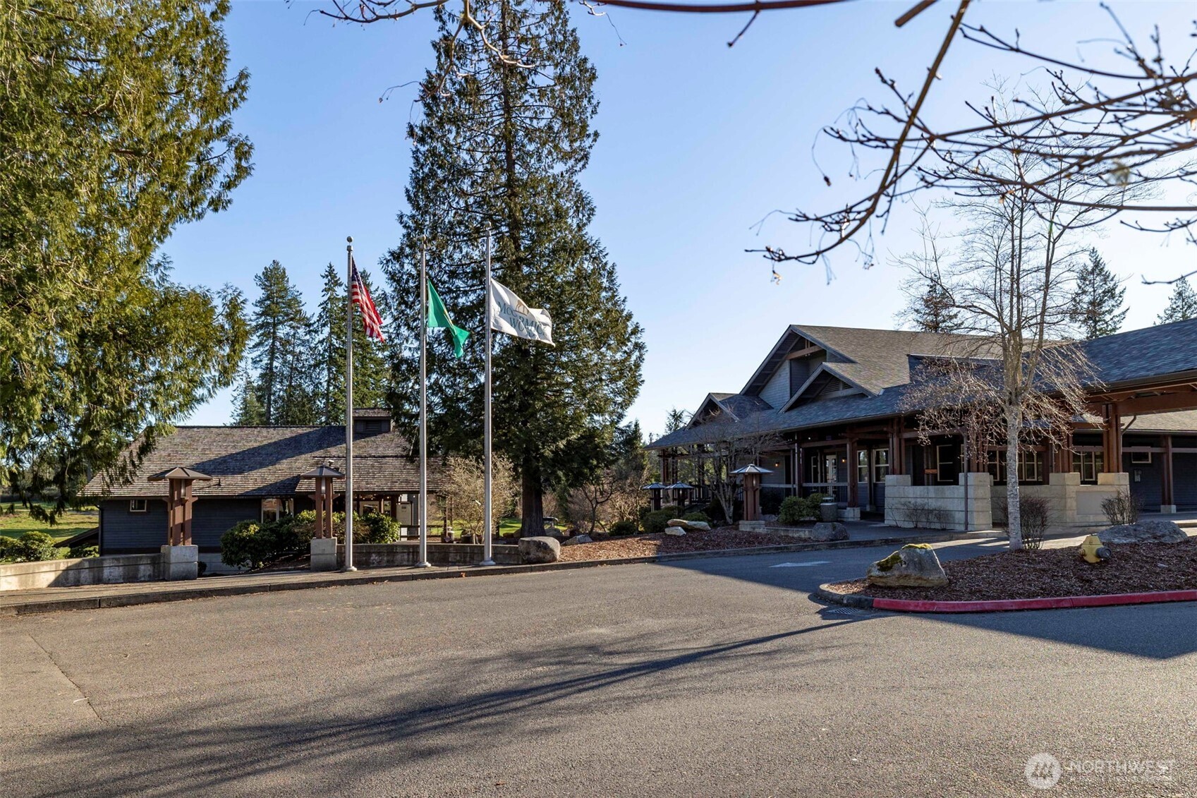 7033 Prestwick Lane Southwest Port Orchard, WA 98367 - Photo 31 of 39 a front view of a building with lots of trees and plants