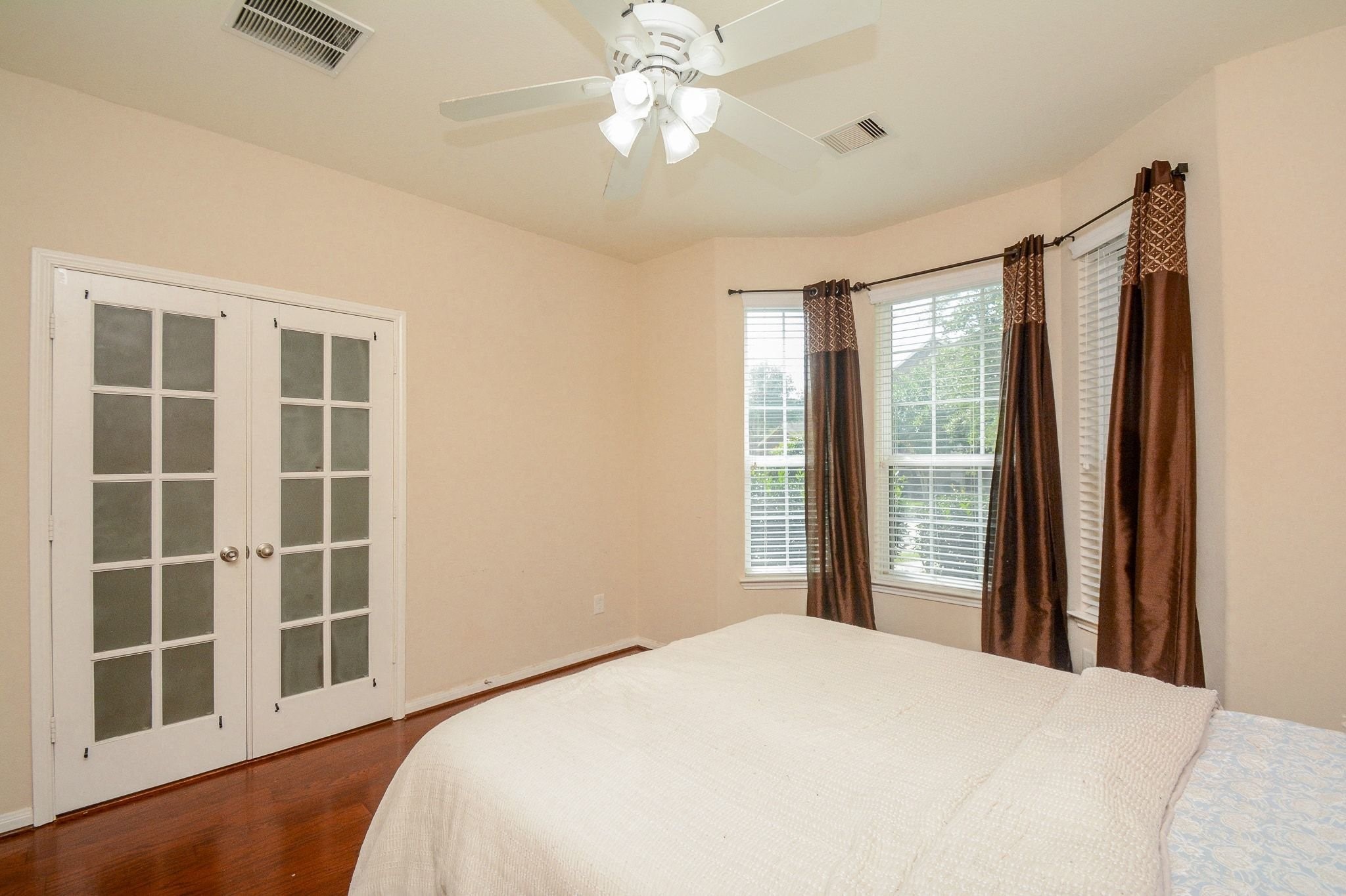 7046 Sliding Rock Circle Spring, TX 77379 - Photo 22 of 41 This inviting study room features elegant French doors, abundant natural light from large windows, and beautiful wood flooring—perfect for productivity and relaxation.Can be usedas Guest Bedroom.
