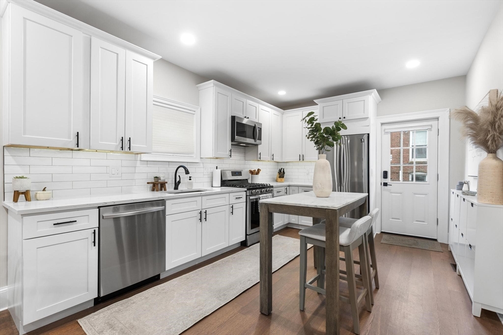 43 Alfred Street, Unit A Everett, MA 02149 - Photo 12 of 29 a kitchen with a sink stove and white cabinets