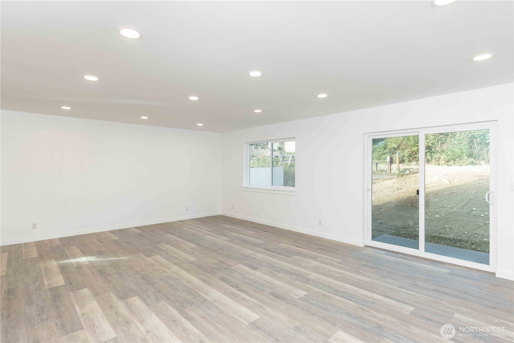 371 East Sullivan Street Allyn, WA 98524 - Photo 4 of 21 an empty room with wooden floor and windows