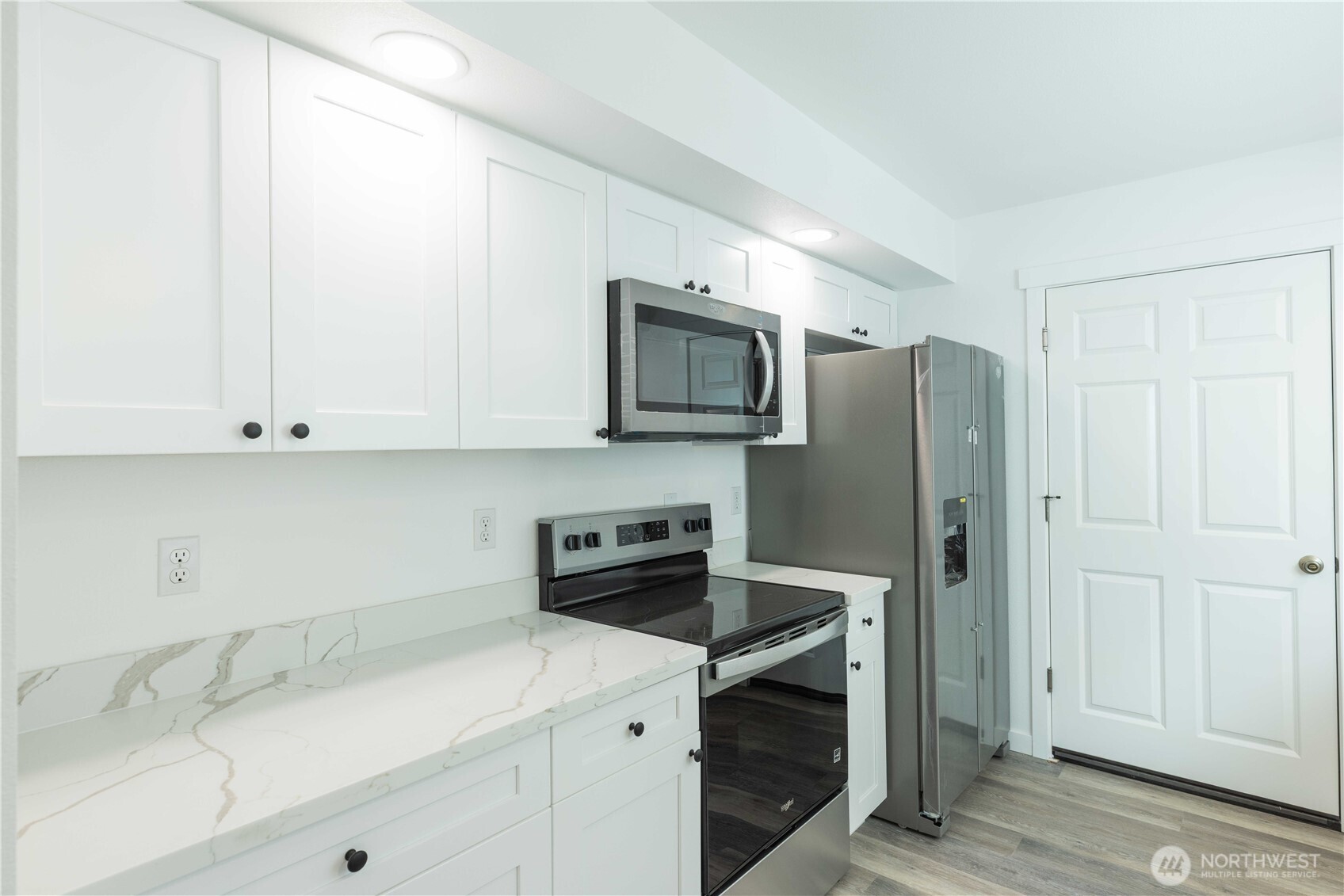 371 East Sullivan Street Allyn, WA 98524 - Photo 6 of 21 a kitchen with stainless steel appliances granite countertop a refrigerator a stove a sink and white cabinets with wooden floor