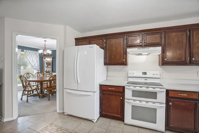 a kitchen with a stove top oven and chairs