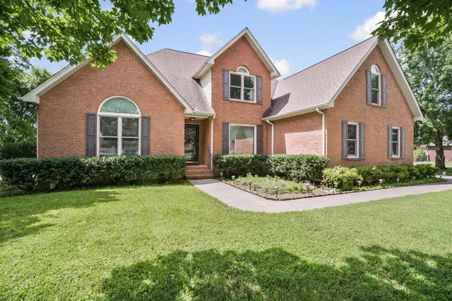 a front view of a house with yard and green space
