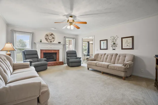 a living room with furniture a fireplace and a chandelier