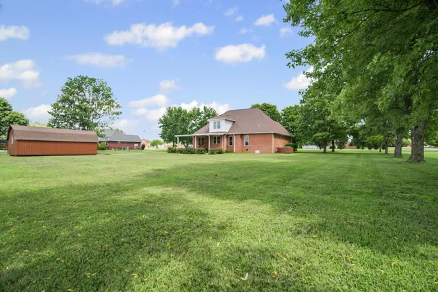 a front view of a house with a yard and trees