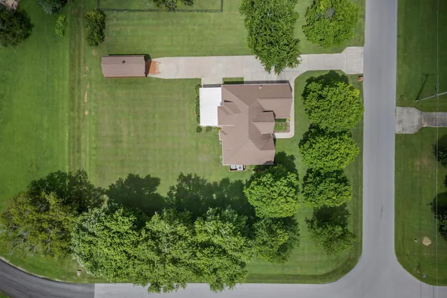 an aerial view of a houses with a yard and lake view