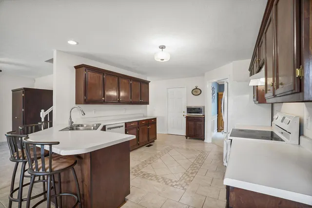 a kitchen with stainless steel appliances a sink and a refrigerator