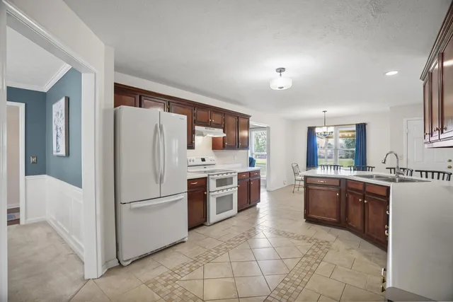 a kitchen with stainless steel appliances granite countertop a refrigerator and a stove top oven