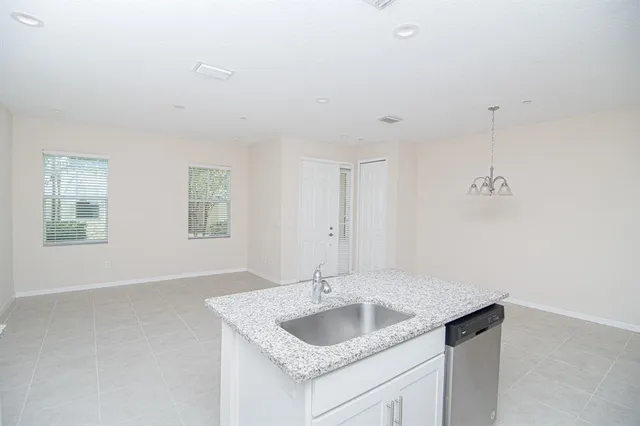 a bathroom with a granite countertop sink and a window