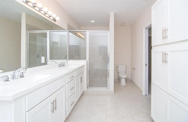 a spacious bathroom with a double vanity sink and a mirror
