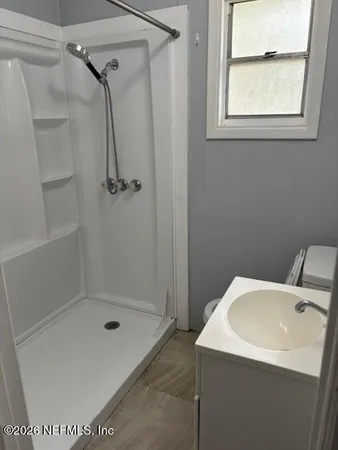 a bathroom with a sink a toilet and shower