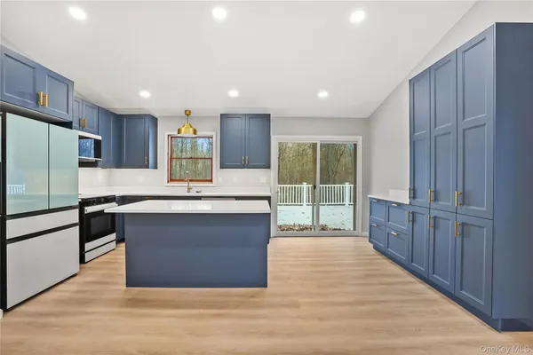 a kitchen with kitchen island a sink stainless steel appliances and cabinets