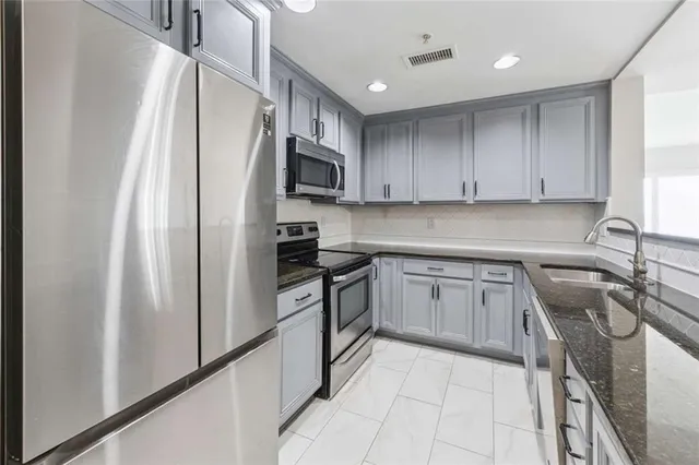 a kitchen with a sink a stove top oven and refrigerator