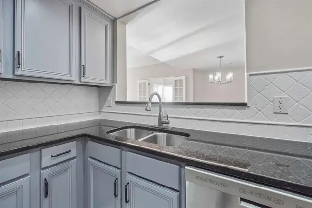 a kitchen with granite countertop white cabinets and a sink