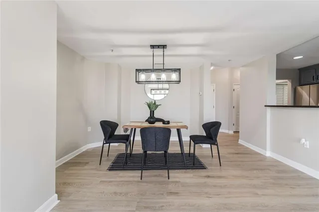 a dining room with furniture wooden floor a rug and a chandelier