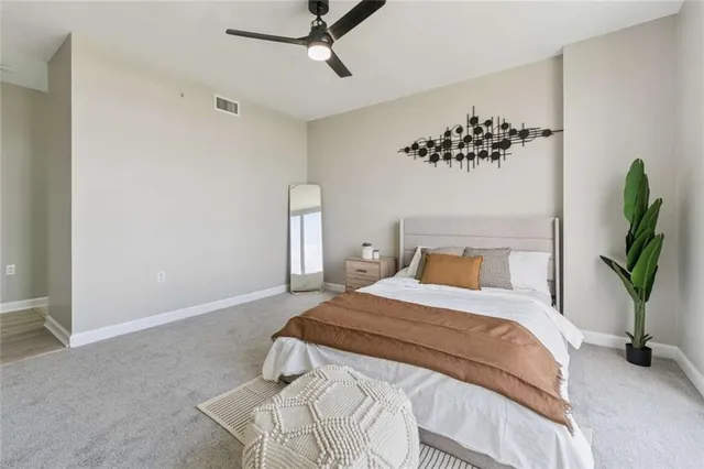 a bedroom with a large bed and a potted plant