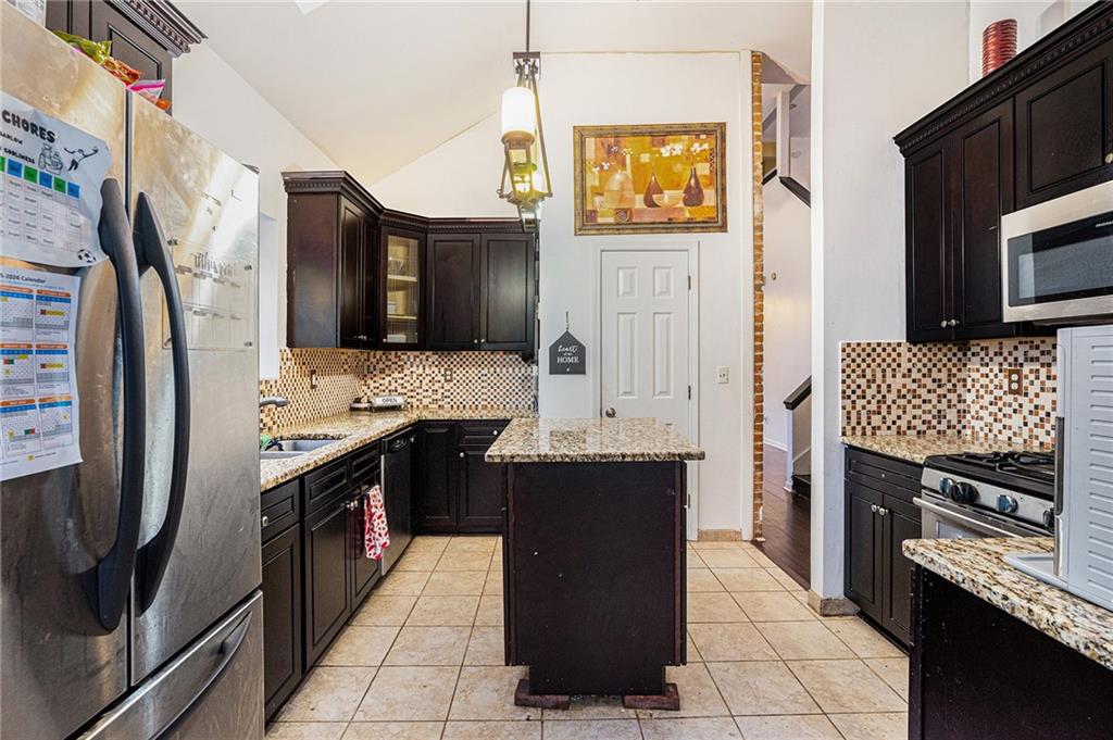 6507 Rebecca Way Lithonia, GA 30058 - Photo 10 of 31 a kitchen with stainless steel appliances granite countertop a stove refrigerator and microwave