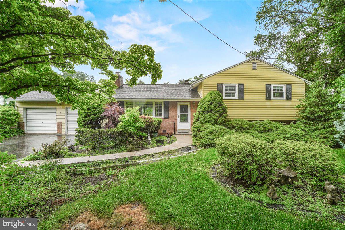 a front view of a house with a yard and trees
