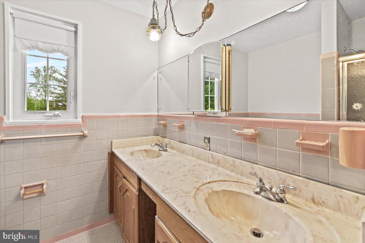 704 Ednor Road Ashton, MD 20861 - Photo 20 of 39 a bathroom with a granite countertop sink a mirror and a shower