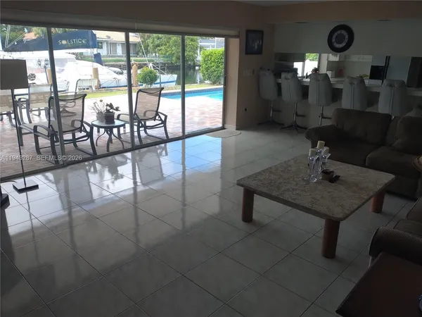 a living room with furniture and a floor to ceiling window