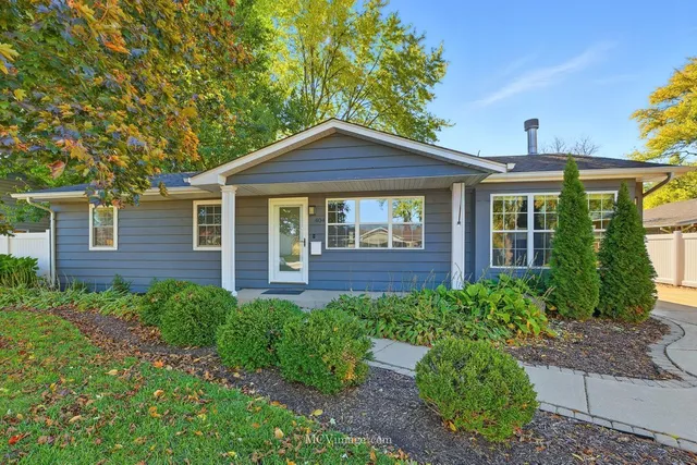 a front view of a house with yard and green space