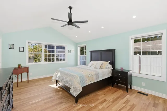 a bedroom with a bed and wooden floor