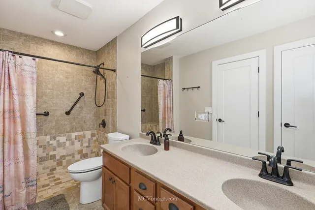 a bathroom with a sink a toilet and shower