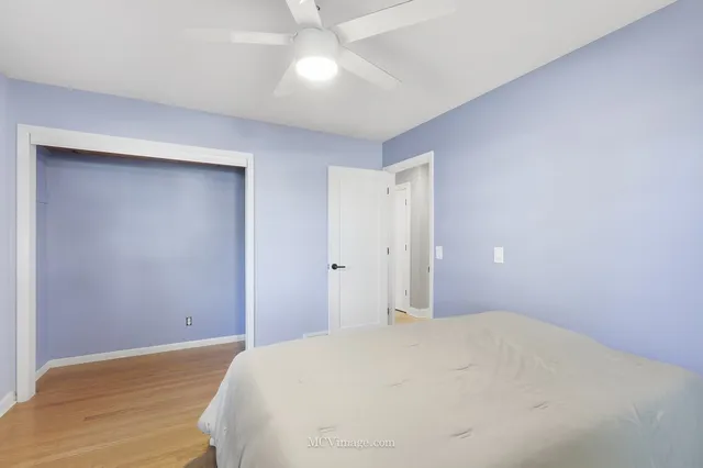 a bedroom with a bed and a ceiling fan