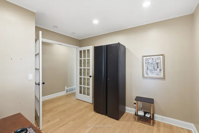 a view of a hallway with wooden floor and a workspace