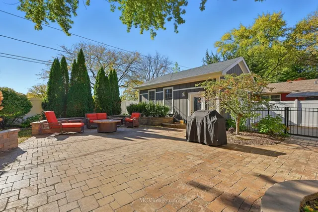 a view of a patio with table and chairs potted plants and a large tree