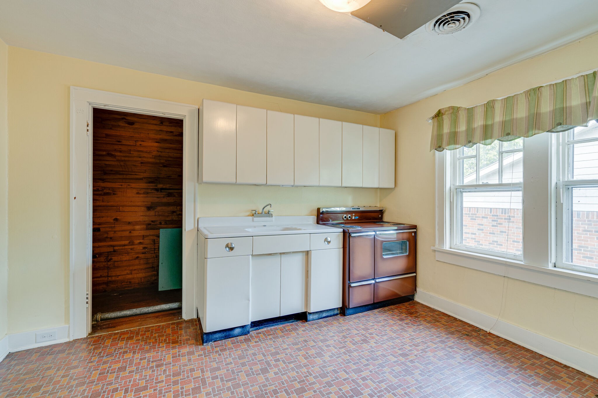 233 Cherokee Road Nashville, TN 37205 - Photo 25 of 29 a kitchen with a stove cabinets and a window