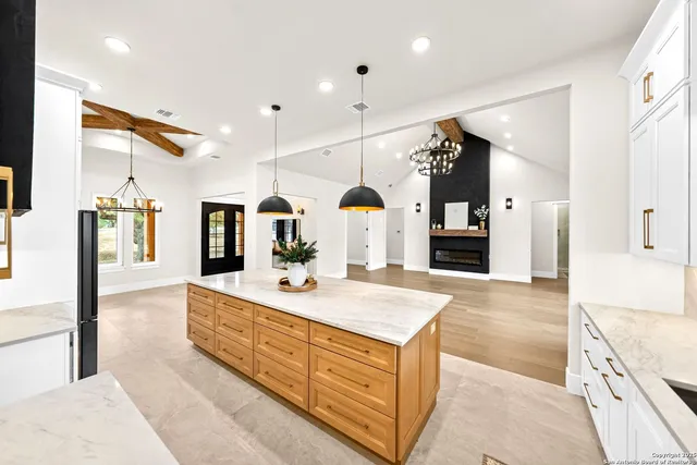 a large white room with kitchen view and living room view