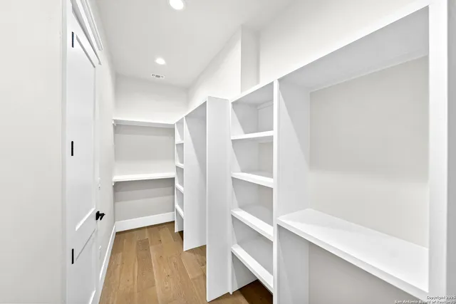 a view of a room with wooden floor and windows