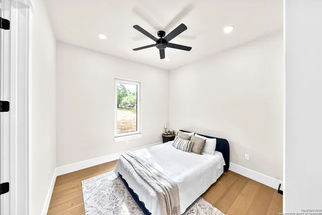 a view of a livingroom with a ceiling fan & windows