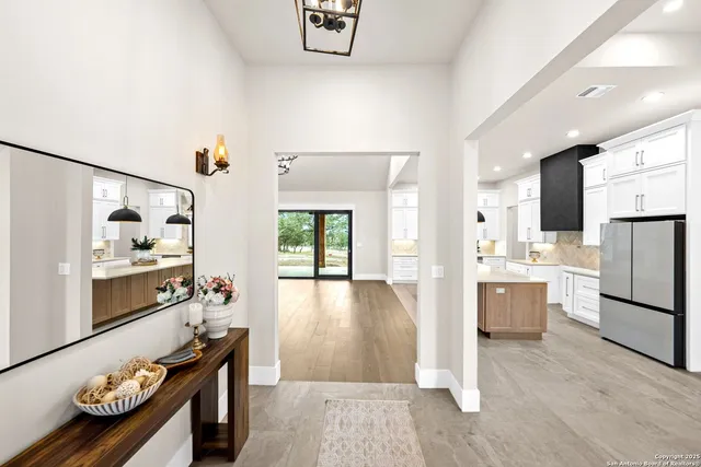 a view of an empty room with a fireplace and a chandelier