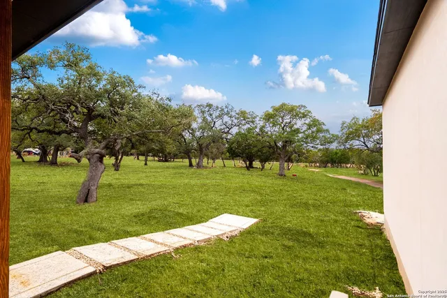 a view of a fountain in front of a house with a big yard