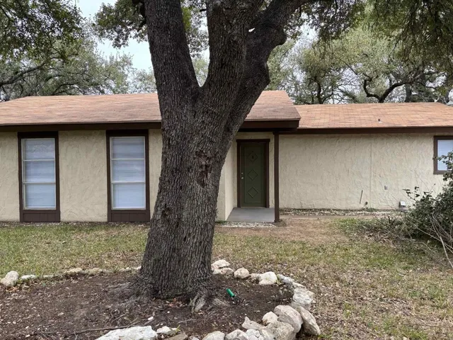 a wooden house with tree in front of it