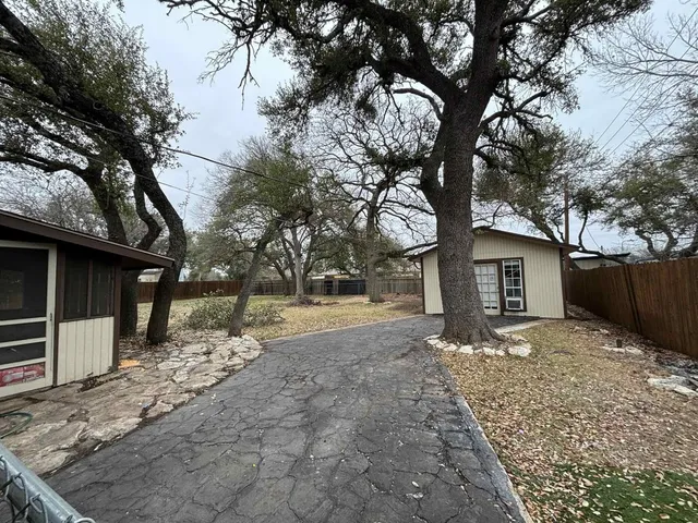 a wooden house with trees in front of it