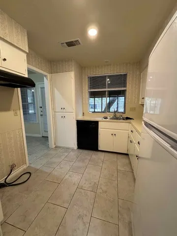a kitchen with white cabinets and white appliances