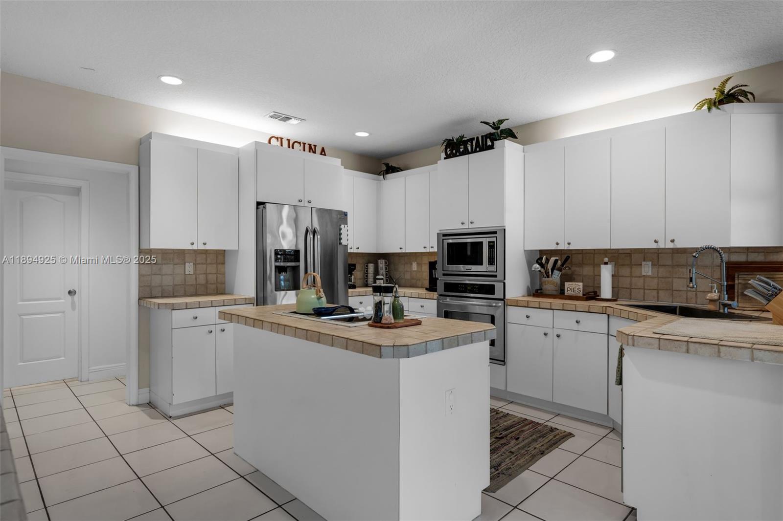 12019 Southwest 77th Terrace Miami, FL 33183 - Photo 19 of 67 a kitchen with kitchen island granite countertop appliances cabinets and a sink