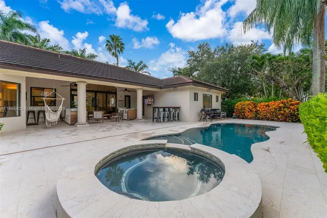 a swimming pool view with a seating space